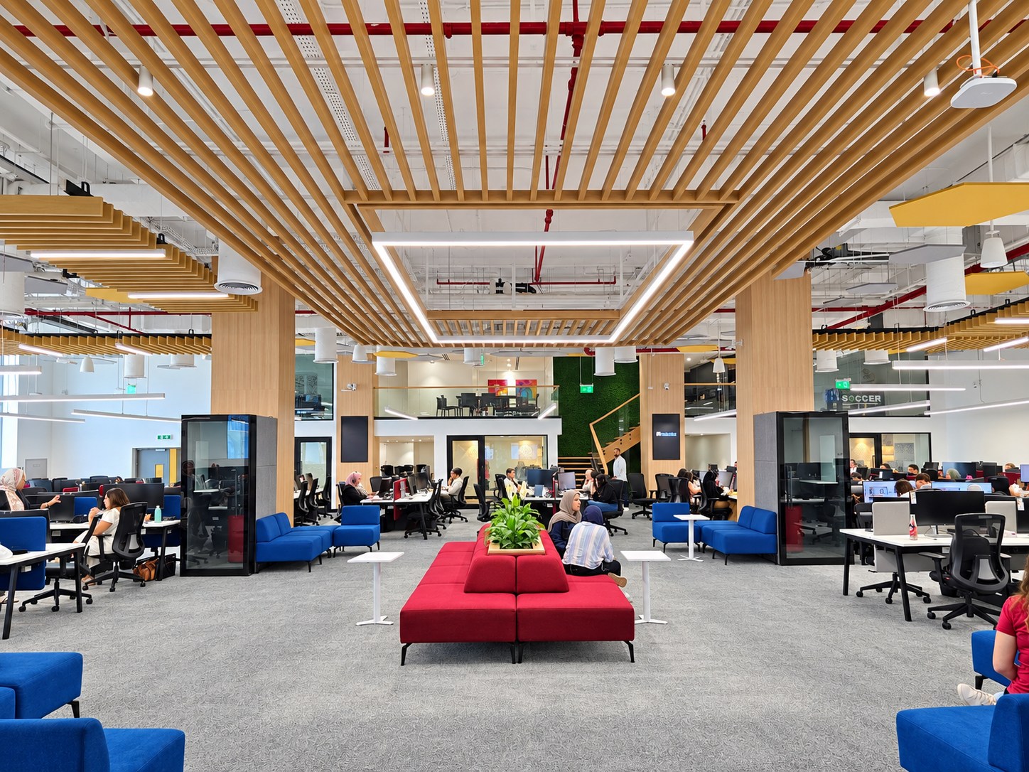 Open-plan office interior with a timber slat ceiling, workstations and shared seating