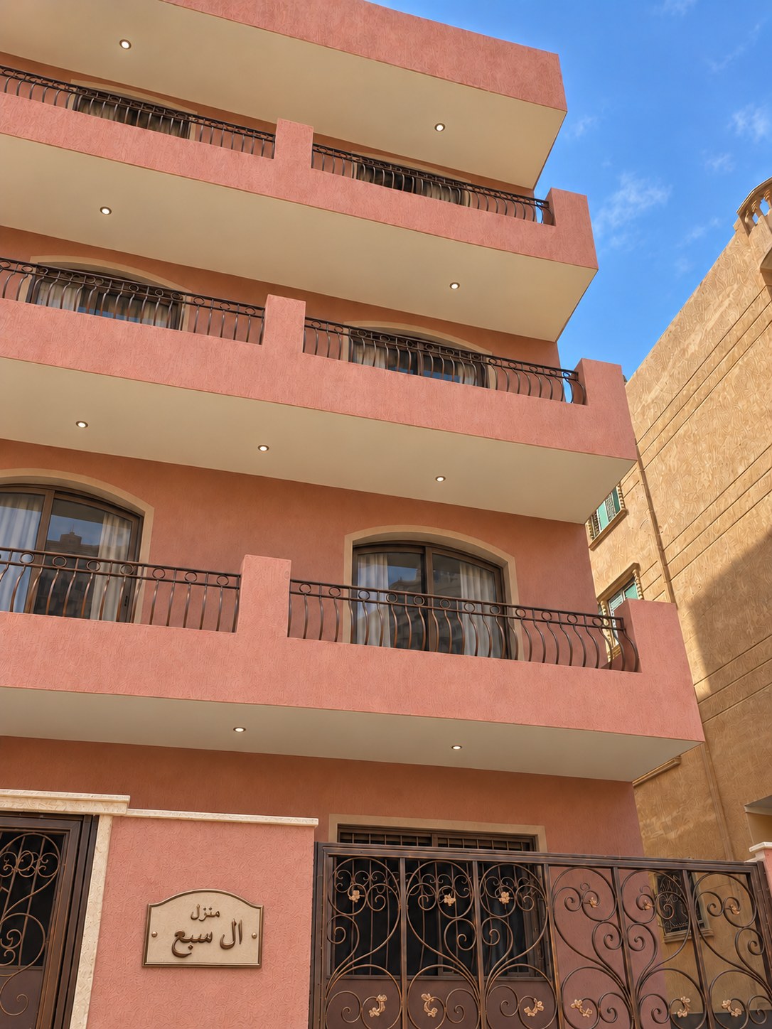 Building 1045 - Hassouba Residence — rose facade and entrance plaque