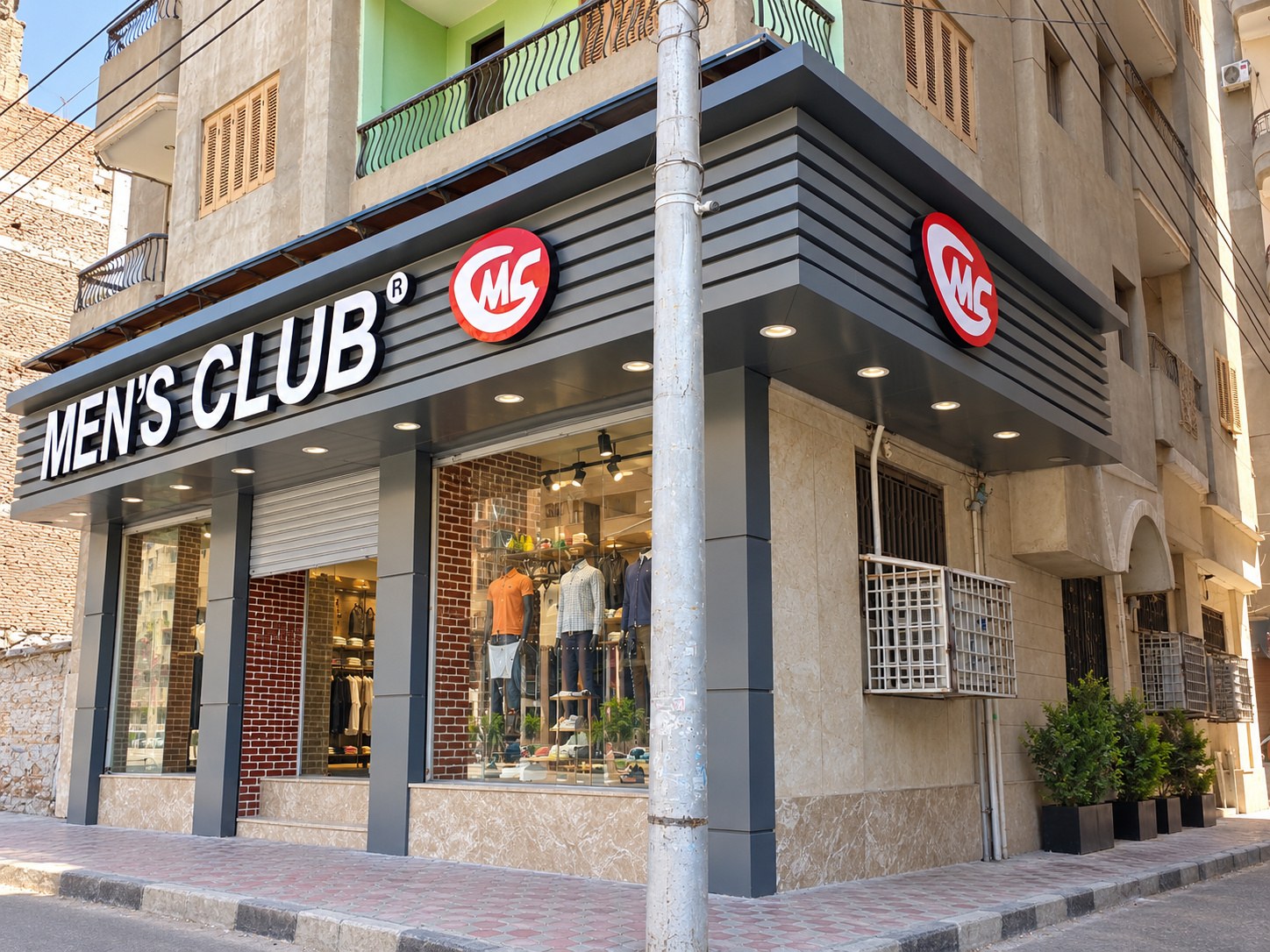 Men's Club - Mansoura 1 — corner storefront and logo