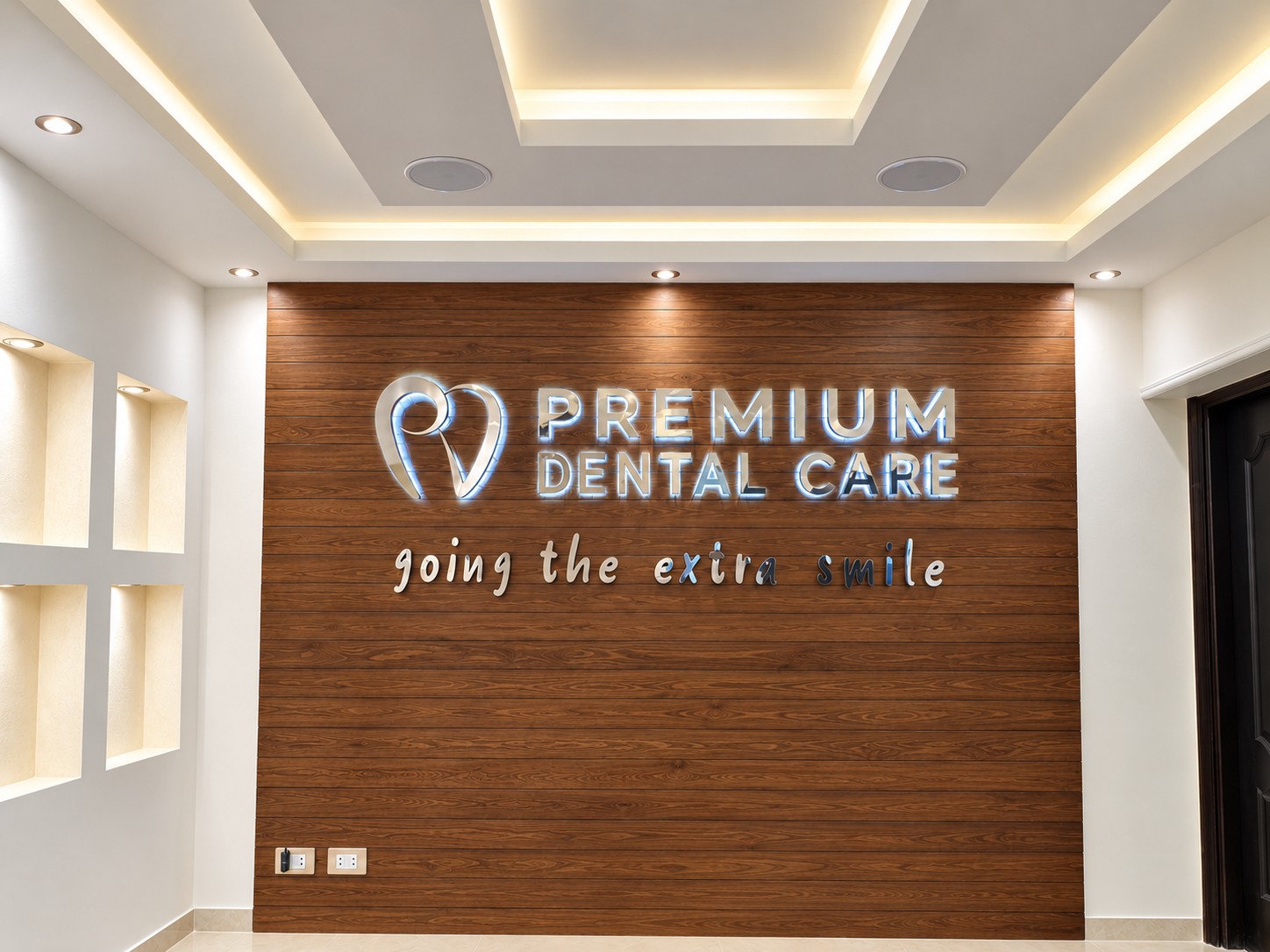 Premium Dental Care illuminated logo on the walnut feature wall